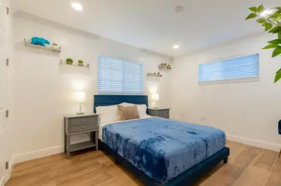 a bedroom with a bed and a desk and two windows at Lakefront Villa and Paddle Board TGH in Miami