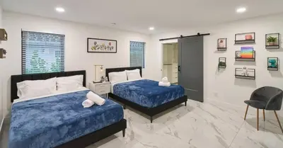 a bedroom with two beds and a chair at Luxurious Villa with Elegant Interior and Mini Golf TGH in Hollywood