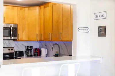 a kitchen with wooden cabinets and a sink at Vista Mar: Bay Views Close to Miami Attractions in Miami Beach
