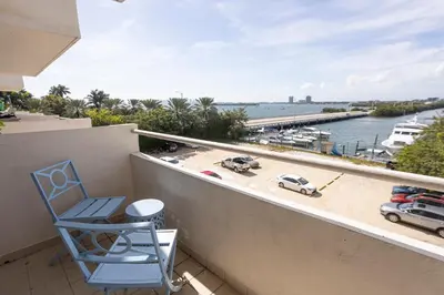 a chair on a balcony with a view of a marina at Vista Mar: Bay Views Close to Miami Attractions in Miami Beach