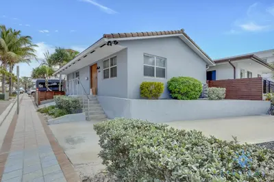 a white house with bushes in front of it at Beach Paradise, Family - Friendly, Free Parking in Hollywood