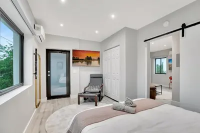 a bedroom with a large bed and a chair at Condo Right off Las Olas - Steps to FTL Beach 2A in Fort Lauderdale