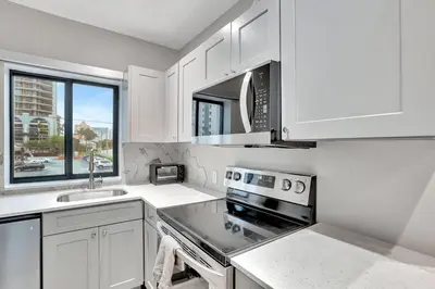 a kitchen with white cabinets and a stove top oven at Condo Right off Las Olas Steps to FTL Beach 1A in Fort Lauderdale