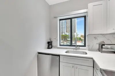 a white kitchen with a sink and a window at Condo Right off Las Olas Steps to FTL Beach 1A in Fort Lauderdale