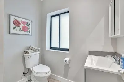 a white bathroom with a toilet and a sink at Condo Right off Las Olas Steps to FTL Beach 1A in Fort Lauderdale