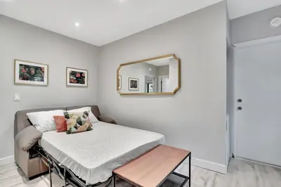 a bed in a room with a mirror on the wall at Condo Right off Las Olas Steps to FTL Beach 1A in Fort Lauderdale
