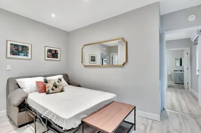 a room with a bed with a mirror and a table at 2 Condo Combo Walk to Beach Off Las Olas 2AB in Fort Lauderdale