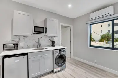 a white kitchen with a washing machine and a window at Studio Right off Las Olas - Steps to FTL Beach 1B in Fort Lauderdale