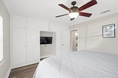 a white bedroom with a ceiling fan and a bed at Wills off Wilton Drive 2 bed and 1 bath plus Den with Heated Pool in Fort Lauderdale