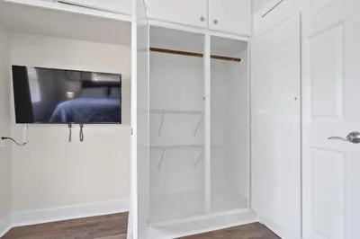 a room with white cabinets and a tv on a wall at Wills off Wilton Drive 2 bed and 1 bath plus Den with Heated Pool in Fort Lauderdale