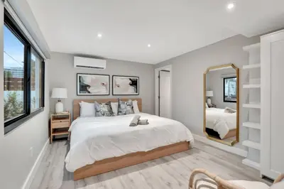 a bedroom with a large bed and a mirror at Lux Villa 3br 2ba off Las Olas in Fort Lauderdale