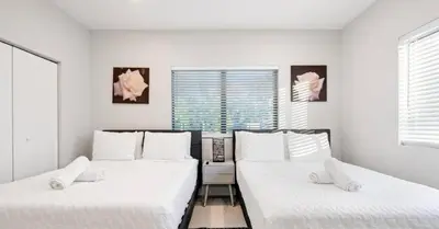 two beds in a room with white walls and windows at Sunny Isles Beach Luxury Property by Glam Homes in Miami