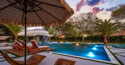a swimming pool with chairs and an umbrella at Sunny Isles Beach Luxury Property by Glam Homes in Miami