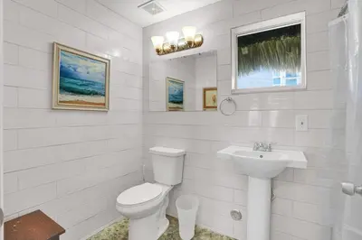 a white bathroom with a toilet and a sink at Beach Condo - Hollywood Beachfront and Broadwalk in Hollywood