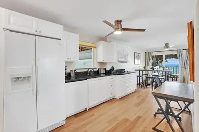 a kitchen with white cabinets and a table and a dining room at Beach Condo - Hollywood Beachfront and Broadwalk in Hollywood