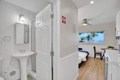 a white bathroom with a sink and a mirror at Beach Efficiency - Hollywood Beachfront and Broadwalk in Hollywood