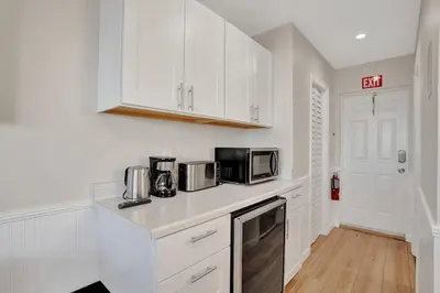 a white kitchen with white cabinets and a microwave at Beach Efficiency - Hollywood Beachfront and Broadwalk in Hollywood