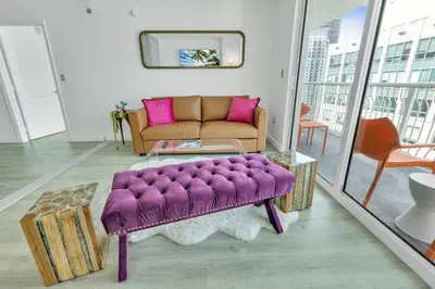 a living room with a purple couch and a table at Oceanside Penthouse Apartment in Brickell Miami, Pool, Free Parking in Miami