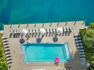 an overhead view of a swimming pool with lawn chairs at Modern Resort Retreat Steps from the Beach in Hallandale Beach