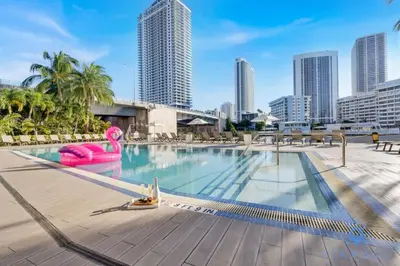 a swimming pool with a city skyline in the background at Modern Resort Retreat Steps from the Beach in Hallandale Beach