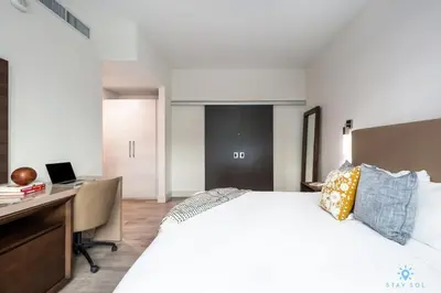 a bedroom with a bed and a desk with a laptop at Amazing Pool - Hot Tub - Gym - Near Beach in Hollywood