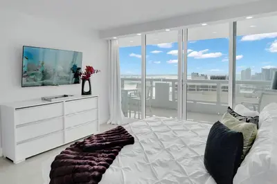 a bedroom with a white bed and a large window at Shades of Miami Sky Penthouse! Newly Renovated in Miami
