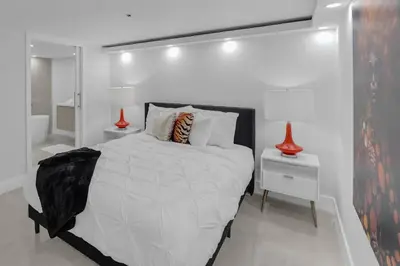 a white bedroom with a large bed and a bathroom at Shades of Miami Sky Penthouse! Newly Renovated in Miami