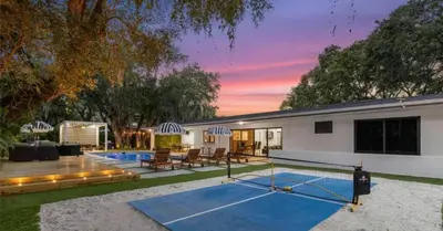 a tennis court in the backyard of a house at Entertaining Villa Fun Games Mini Golf Grill in Miami