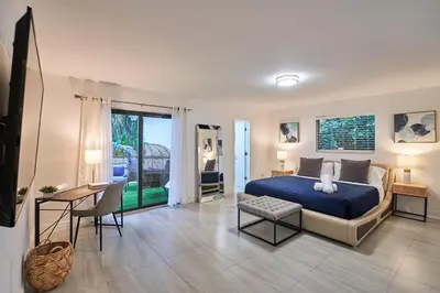 a bedroom with a blue bed and a table and chairs at Lakefront Villa: Tropical Backyard & Kayak TGH in Miami