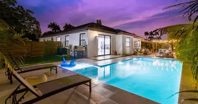 a swimming pool in front of a house at Tropical Villa wJacuzzi Big Terrace & Billiards in Miami