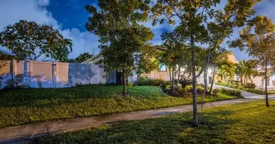 a house with a fence and trees in a yard at Tropical Villa wJacuzzi Big Terrace & Billiards in Miami