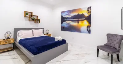 a bedroom with a bed and a chair at Tropical Villa wJacuzzi Big Terrace & Billiards in Miami