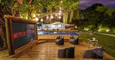 a stage with a projection screen and some chairs at New Hidden Gem in Miami
