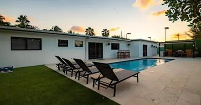 a group of chairs sitting next to a swimming pool at Luxurious Retreat with Tennis and Soccer Courts TGH in Miami