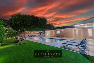 a house with a swimming pool with a sunset at Villa w/a Huge Terrace & Grill Mini Golf Pool in Miami