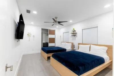 a bedroom with two beds and a flat screen tv at Villa w/a Huge Terrace & Grill Mini Golf Pool in Miami