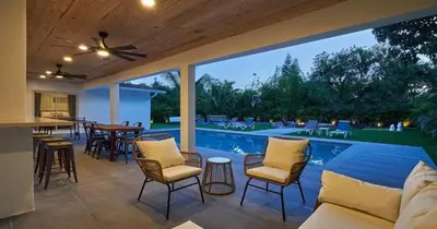 a patio with a pool and chairs and a table at Villa Athena - The Glamhomes in Miami