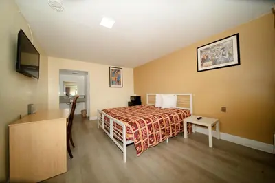 a bedroom with a bed and a desk and a television at Sinbad Motel in Miami