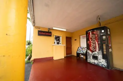 a cocacola machine in a yellow room with a vending machine at Sinbad Motel in Miami