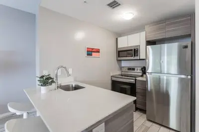 a kitchen with a sink and a refrigerator at Wynwood Amazing Condo Sleeps 5 Close to Beach in Miami