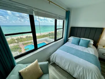 a bedroom with a bed and a view of the ocean at Directly on the Beach with Pool & Ocean View in Miami Beach