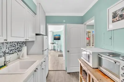 a kitchen with white cabinets and a sink at Panoramic beachfront Suite in Hollywood