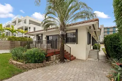 a house with a palm tree in front of it at DOWNTOWN LAS OLAS WATERFRONT HOME UPDATED UNIT in Fort Lauderdale