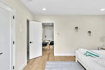 a white room with a bed and a table at 1 bedroom tropical pool house in Hallandale Beach
