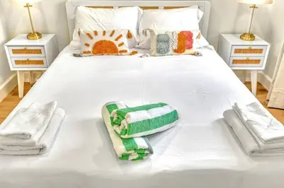 a white bed with towels and towels on it at 1 bedroom tropical pool house in Hallandale Beach