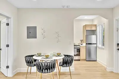 a kitchen with a table and chairs and a refrigerator at 1 bedroom tropical pool house in Hallandale Beach
