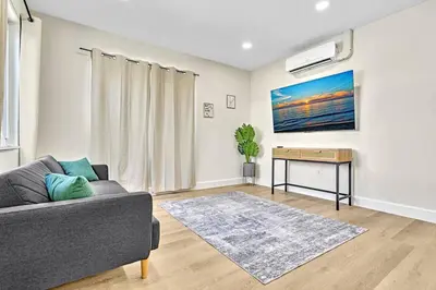 a living room with a couch and a table at 1 bedroom tropical pool house in Hallandale Beach