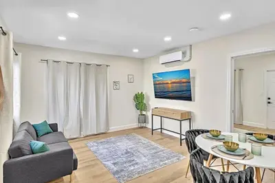 a living room with a couch and a table at 1 bedroom tropical pool house in Hallandale Beach