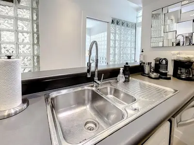 a kitchen with a stainless steel sink in a kitchen at CasaGrandeSouthBeach by AmericanVacationLiving 6BR in Miami Beach