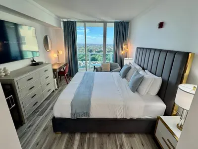 a hotel room with a large bed and a desk at Balcony Ocean View ! Pool - WiFi - Gym - Parking in Miami